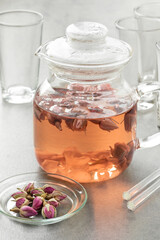 Glass teapot with dried rose buds tea as an aromatic hot drink 