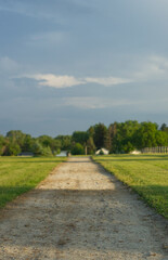 Fototapeta na wymiar View of a straight gravel path in the park