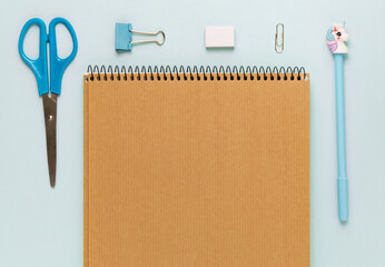 Top view of modern white blue office desktop with school supplies and stationery on table around empty space for text. Back to school concept flat lay with mockup