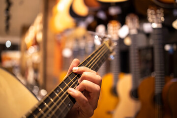 Close up view of talented musician playing guitar in music shop.