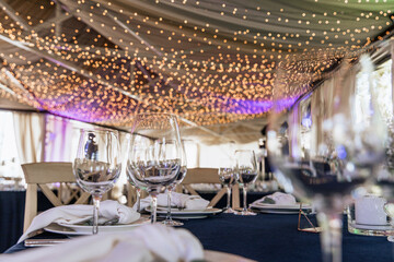 Champagne glasses. Candles and flowers. Banquet table decoration.