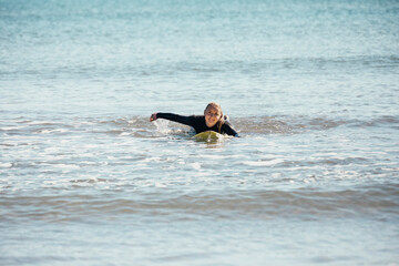 Girl swimming on a surfboard in the sea. 