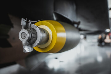 Close up view of an unguided bomb attached to a wing of a fighter airplane. Concepts of bombing and modern wars in syria, iraq, afghanistan.