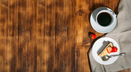 coffee and cheesecake with strawberries on wooden background 