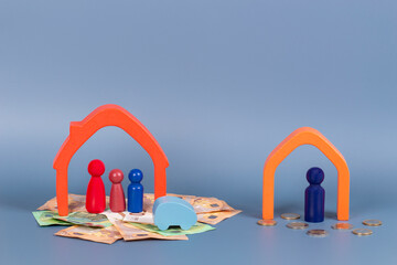 Divorce, conflict between parents, children custody, property division. Wooden houses, miniature figures of parents and children, cash money on gray background