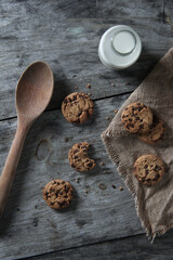 chocolate chip cookies and milk on wooden table 