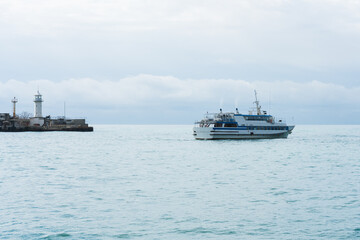 A pleasure ship with tourists leaves the port in the early spring morning