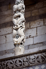 Lucca (Tuscany, Italy), church of San Michele. Details of the columns and arches of the medieval facade, with inlays and sculpture of sirens, monsters, dragons and animals