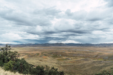 Fototapeta premium sunset in the peruvian andes the sun bathing the hills in the distance in yellow and surrounded by queñua trees with the blue sky