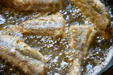 Pescado friéndose en aceite hirviendo, boquerones y mairas