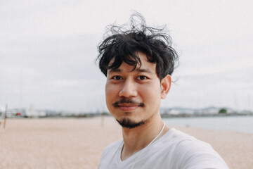 Happy Asian man selfie himself relaxed on the beach. Concept of summer holiday.