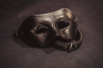 top view of collar and black mask on black textile background