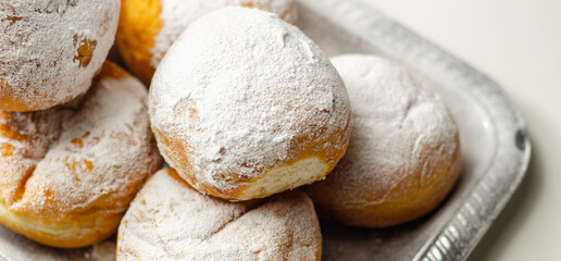Berliner Pfannkuchen, a German donut, traditional yeast dough deep fried filled with chocolate cream and sprinkled with powdered sugar