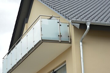 Balkon mit Edelstahl-Geländer und Sichtschutz aus Milchglasplatten an der Fassade eines modernen...
