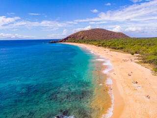 A huge sandy beach. Green hill between blue sea and sky. Amazing waves on the sand. Makena beach, Maui, Hawaii