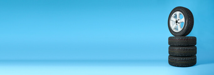 car wheels with winter studded tires on a blue background. set of winter wheels on large format...