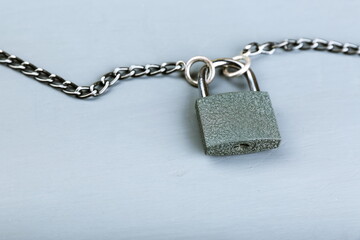 Fototapeta na wymiar locked padlock with chain on gray concrete background with copy space