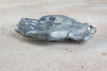 Old aluminum bird feeder on concrete background.