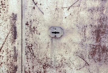 Keyhole on an old damaged metal door