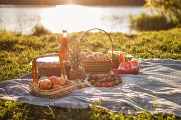 Picnic by the lake. Basket with berries, bread with ik. Nobody.