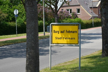 Ortseingang von Burg auf Fehrmann mit Ortsschild bei Sonnenschein