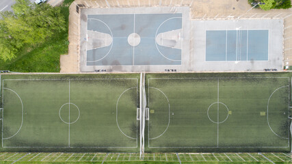 Top down view of publik football, soccer fields, tennis court and basketball field in the park.