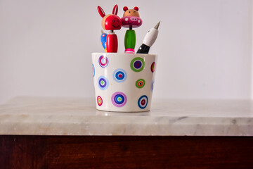 children's pens and colored pencils in a cup

