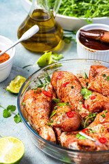 Raw Chicken Drumsticks Legs Marinating in Herbs and Hot Spices for BBQ Grill