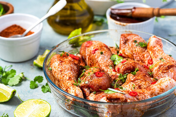 Raw Chicken Drumsticks Legs Marinating in Herbs and Hot Spices for BBQ Grill