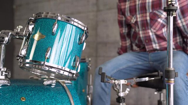 close up of Drums on the background male is Setting Up A Drum Set  before Rehearsing - Drum Lesson. 