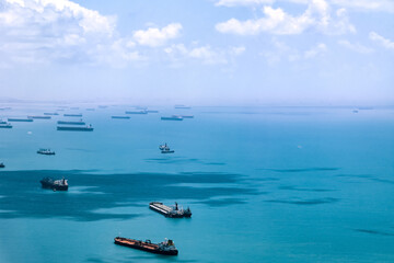 Aerial view of container ships in Singapore Strait. Airplane shot. Cargo ships anchored in the road, waiting to enter the busiest port in region. 