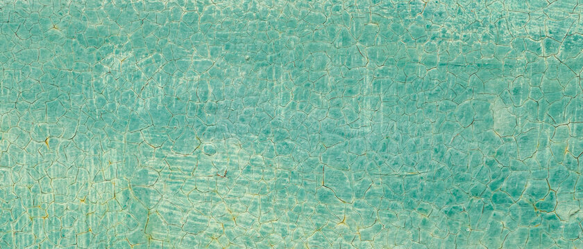 Cracked turquoise paint texture. Old crackled teal turquoise painted wood surface. Green turquoise painted cracked wall texture