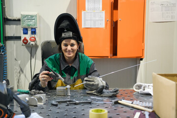 A woman employed in a modern factory for the production and processing of metals in a work uniform...