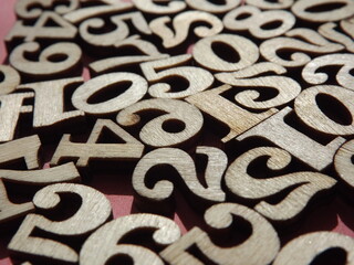 wooden numbers are randomly arranged on pink suede. High quality photo
