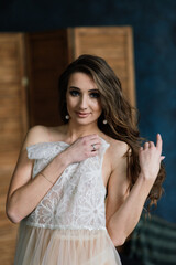 Beautiful bride in white lingerie sitting in her bedroom and studio.