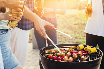 Man working on the grill, man doing barbecue for friends on the grill, outdoor, barbecue party