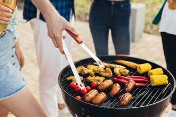 Man working on the grill, man doing barbecue for friends on the grill, outdoor, barbecue party