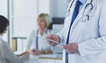Portrait of senior doctor in office sitting at the desk