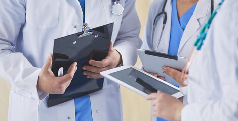 Doctor showing something in his tablet to his medical team