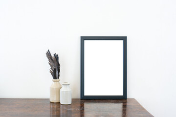 empty photo frame on wooden table with inkwells