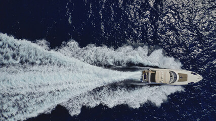 Aerial drone top down photo of luxury yacht with wooden deck cruising in the Aegean deep blue sea, Greece