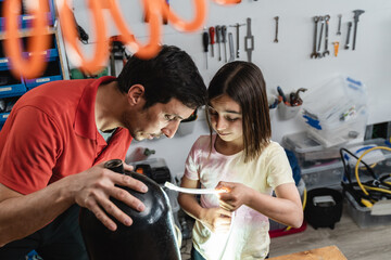 Father and daughter working at scuba diving workshop - Family teamwork concept - Focus on girl face