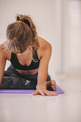 Fototapeta na wymiar Woman doing stretching exercise on yoga mat