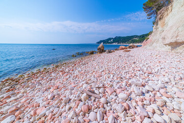 Pebbles beach colorful bay in Conero natural park dramatic coast headland rock cliff adriatic sea tourism destination Italy turquoise transparent water