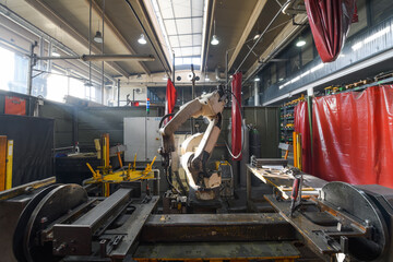 Fototapeta na wymiar Automatic welding robot mechanical arm is working in the modern automobile parts factory.