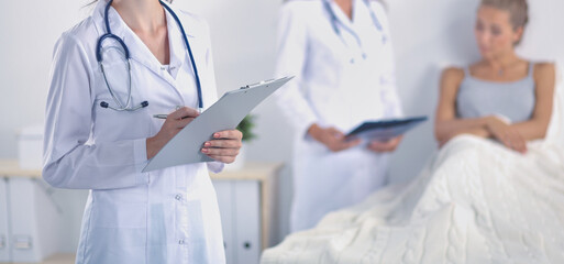 Woman doctor with folder standing at hospital. Woman doctor