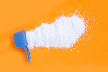 Detergent powder with measuring spoon for clothes washing. Laundry concept.