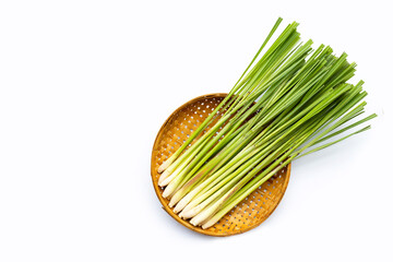 Fresh lemongrass in bamboo basket on white background.