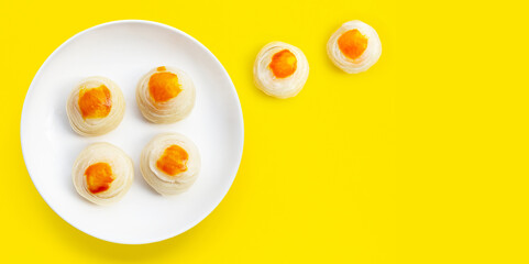Chinese pastry in white plate on yellow background.