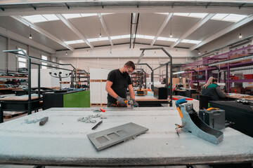 Heavy Industry Engineering Factory Interior with Industrial Worker Using Angle Grinder and Cutting...
